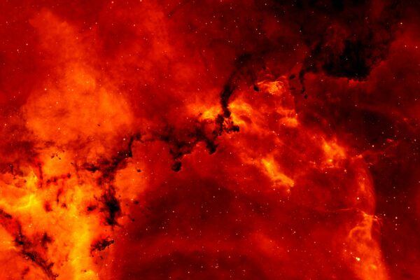 A stunning view of a red cosmic nebula, glowing intensely against a backdrop of stars.