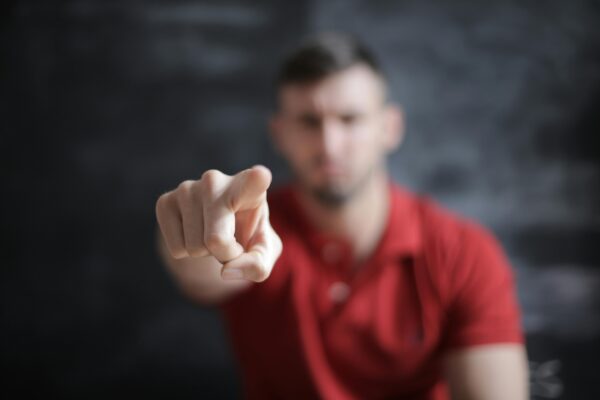 Blurred man pointing forward, emphasizing index finger close-up.