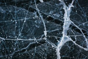 Aerial view of intricate ice cracks on Lake Baikal's surface, showcasing winter's beauty.